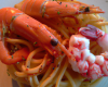 Duo de langoustines et gambas enrobe rouge sur nid de spaghettis