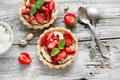 Tartelette aux fraises, crème à la pistache accompagnée d'une sucette de fraises glacée aux framboises entières