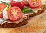 Tartine de jambon cru sur lit de tomates et mozzarella