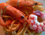 Duo de langoustines et gambas enrobe rouge sur nid de spaghettis