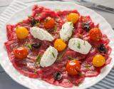 Carpaccio de bœuf, tomates confites, olives noires au Tartare ail et fines herbes