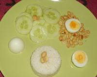 Cuire le riz dans le lait de coco. Préparer les oeufs durs.