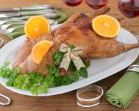 Un canard rôti servi avec une sauce à l'orange.