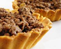 Un crumble sucré disposé sur une pâte sablée maison