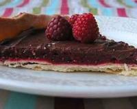 Une "compote" de fruits rouges sur une pâte sablée ; le tout recouvert de ganache au chocolat noir