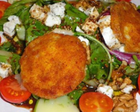 Une salade fraiche et croquante agrémentée de feta et de noix, sur laquelle trônent de jolis petits chèvres panés, croustillants et fondant.