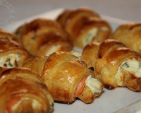 Des petits croissants en pâte feuilletée fourrés avec du fromage frais à la ciboulette et du saumon fumé.
