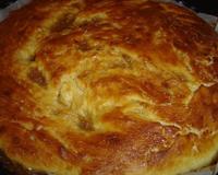 Tourte avec de la pâte briochée ayant pour garniture des pommes de terre et du petit salé.