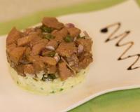 Un tartare de veau légèrement relevé sur un compressé de pommes au fromage de vache pour une association tout en douceur de l'acidité de la pomme et du fromage.