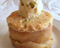 Un dessert à tombé avec des pommes confites entre deux biscuits à la pistaches.
