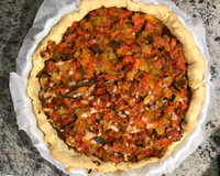 Tous les bons légumes d'une ratatouille : poivrons, aubergines, courgettes, tomates et oignons... déposés sur une pâte brisée, recouverts…