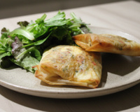 Brick à l'œuf avec oignons, fromage et herbes fraîches