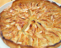 Une pâte sablée recouverte d'une couche de pommes sur un lit de crème aux amandes parfumé au calvados.