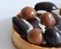 fond de pâte sablée recouvert d'une ganache chocolat noir/gingembre, de chocolat blanc et de friandises en chocolat