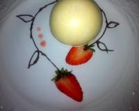 Sous une coque craquante de chocolat blanc, une crème fondante avec un cœur de fraises cliforette sur un sablé.