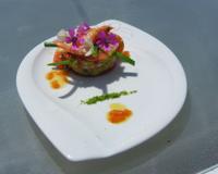 Crevettes roses décortiquées sur un lit de guacamole et une brunoise acidulée de tomates, pamplemousse, oignons nouveaux, gingembre et vinaigrette d'agrumes.