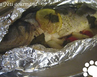 Bar cuit en papillote, servi avec une sauce aux herbes et beurre fondant.