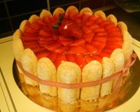 Mousse de fraises dressée avec une ceinture de biscuits à la cuillère et une couverture de fraises finement émincées et recouverte d'une pellicule de nappage blond.