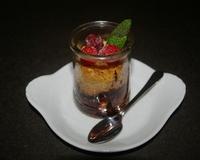 Pâte à crumble avec pétites de chocolat sur framboises arrosées de jus de citron.