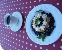 Deux ronds de pâte feuilletée plate garnis de myrtilles et crème chantilly...