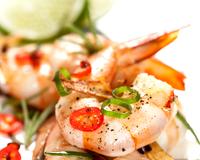 Des crevettes jumbo marinées puis grillées au barbecue, à servir avec des tomates cuites au barbecue aussi.