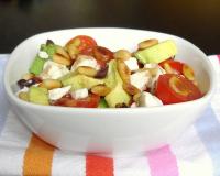 Salade tout en saveurs et jeux de textures : avocats, feta, pignons, tomates et olives noires