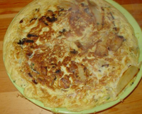 Deux pommes de terre coupées en lamelles fines, 4 ou 5 petites feuilles de chou vert (bouilli). Le tout mélangé avec quelques oeufs, oignons et ail...