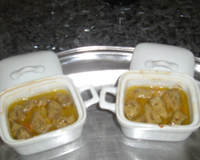 Des blocs de foie gras sur un lit de saint-jacques, avec sauce vin blanc et échalotes
