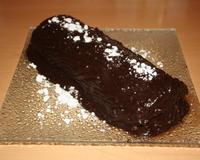 Une bûche au chocolat noir avec une gâteau roulé imbibée d'un sirop au sucre. Flambée au rhum.