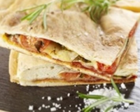 Focaccia garnie de jambon fumé, tomates et gruyère, pesto rosso. A déguster chaud ou froid.