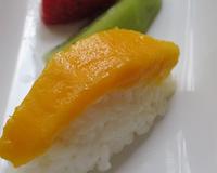 Un sushi sucré au lait de coco recouvert d'une lamelle de mangue fraîche.