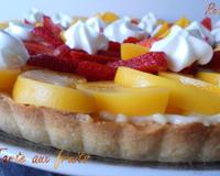 Une tarte sablée fait maison nappée d'une crème pâtissière ; délicatement décoré de fraises et de pêches et d'un soupçon de crème chantilly.