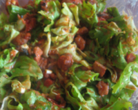 Scarole avec des tomates pelées chaudes et des lardons chauds.