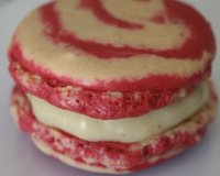 Un macaron bicolore à la crème pâtissière avec un coeur de fraise