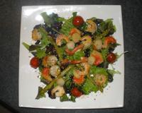 Une salade verte, accompagnée de tomate et cocombre, agrémentée de saumon, crevete et noix de st jacques.