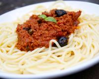 Des spaghetti accompagnés d'une bonne sauce au thon et à la tomate avec des olives noires et des câpres.