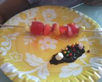 Brochettes de fruits et de bonbons evec du chocolat fondu, des billes de sucre colorés et mini chamallows.