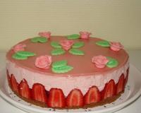 Sur une génoise au chocolat, se cache une mousse à la fraise parsemée de morceaux de fraises, le tout décoré avec un disque de pâte d'amande rose et des roses en pâte…