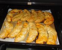 Croissants faits de pâte feuilletée et fourrés avec du steak haché, de l'oignon, du poivron, de l'emmental rapé, de la sauce tomate.