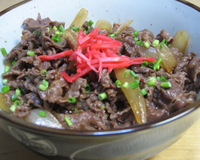 Bol de riz japonais recouvert de fines tranches de boeuf et d'oignons cuits dans un bouillon typiquement japonais.