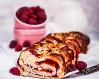 Une brioche roulée avec de la confiture de framboises, idéale pour un petit déjeuner gourmand.