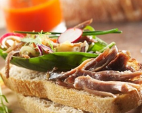 Une recette Labeyrie de confit de canard et crudités sur tartine de pain...