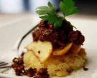 Lit de pommes de terre, poires confites et confit de canard