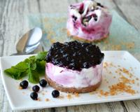 Un fond de pâte à cheesecake garni de Glace Carte d"Or® Façon Glacier saveurs Myrtille et Vanille, surmonté d'un disque de coulis de myrtilles gélifié.