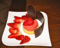 Un sorbet fraise sur un palet sablé, des fraises 'nature' et de fines plaques de chocolat.