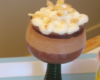 Une couche de crème au chocolat, une couche de mousse pralinée, nappée de sauce chaude au chocolat à l'érable et d'une chantilly citronnée, parsemée d'amandes effilées.