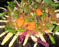 Le verger est représenté par des végétaux plantés dans une purée de tomates mélangée à d'autres ingrédients. Les épis de maïs sont les rayons de soleil qui entourent…