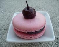 Un macaron agrémenté d'une subtile ganache au chocolat parfumée au jus de griottes qui cache en son coeur des morceaux de cerises à l'eau…
