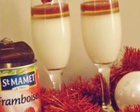 Panna cotta rehaussée d'une gelée de champagne et d'un coulis de framboises.