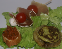 Une salade verte agémentée d'un toast au pistou rouge, d'une galette de pommes de terre et d'une bochette au jambon d'Aoste : une salade aux couleurs de l'Italie.